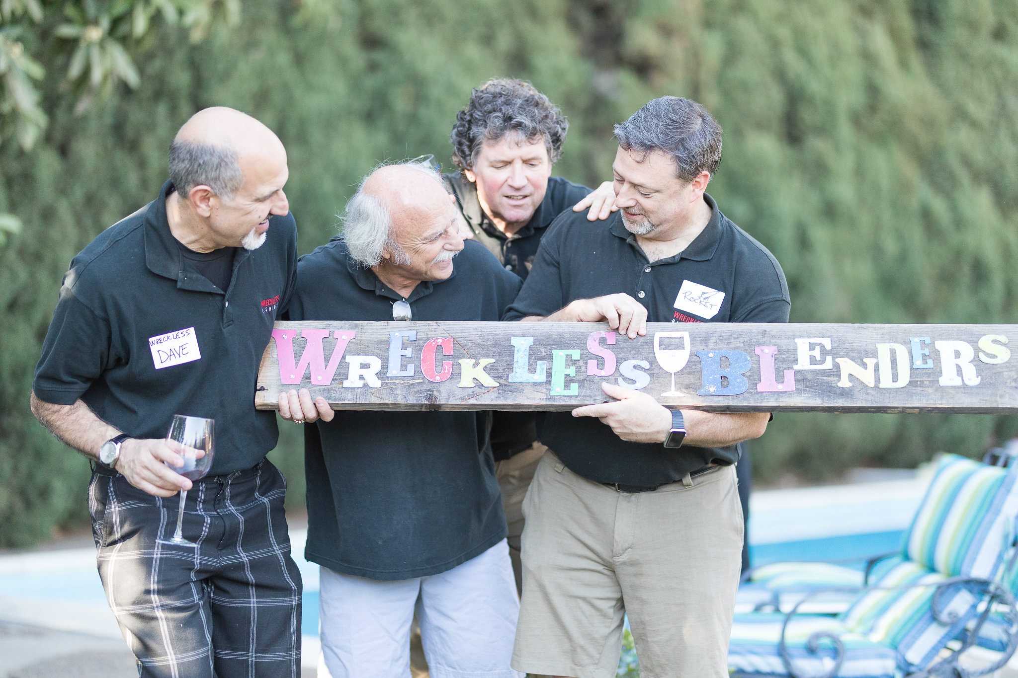 Wreckless Blenders team members smiling together with glasses of wine.
